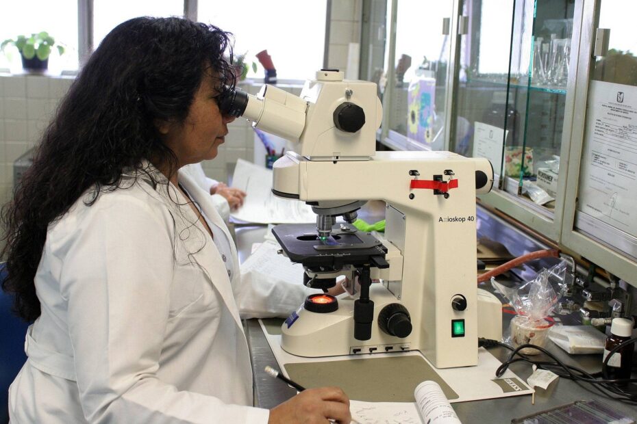 Photo of a woman looking into a microscope in a scientific laboratory
